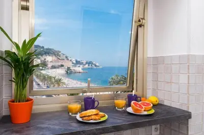 a table with plates of food and a view of the ocean at MY CASA - ETATS UNIS 894 - Stunning on Sea Front w AC in Nice