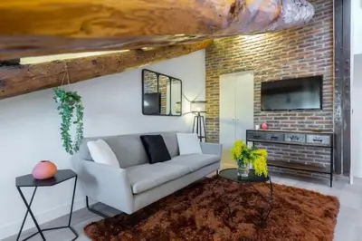 a living room with a couch and a brick wall at MY CASA - MASSENA 44 - Stunning studio on Masséna Square in Nice