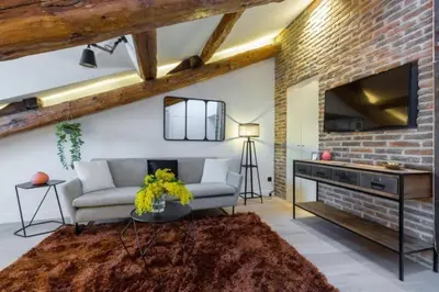 a living room with a couch and a brick wall at MY CASA - MASSENA 44 - Stunning studio on Masséna Square in Nice