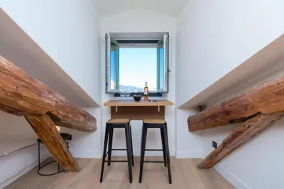 a small room with two stools and a window at MY CASA - MASSENA 44 - Stunning studio on Masséna Square in Nice