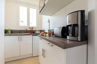 a kitchen with white cabinets and a black microwave at MY CASA - DALPOZZO - 5min walk to beach in Nice