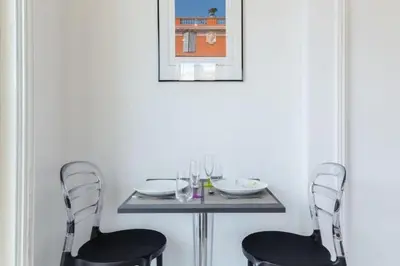 a table with two chairs and a table with glasses on it at MY CASA - DALPOZZO - 5min walk to beach in Nice