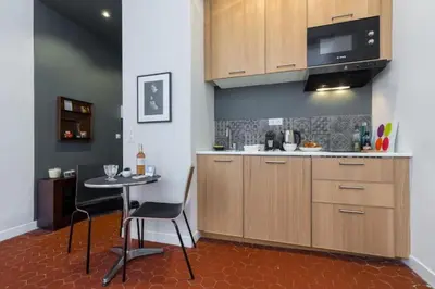 a kitchen with a table and a small table with chairs at MY CASA - DROITE - Bright studio in the Old Town in Nice
