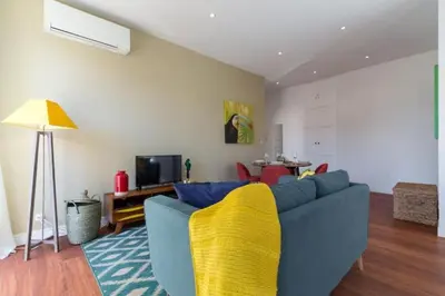 a living room with a blue couch and a yellow blanket at MY CASA - GIOFFREDO 55 - 2 beds w AC on Massena Square in Nice