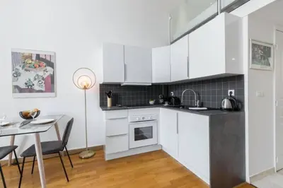 a kitchen with white cabinets and a table with chairs at MY CASA - DELOYE - Spacious Quiet studio w AC near Old Town in Nice