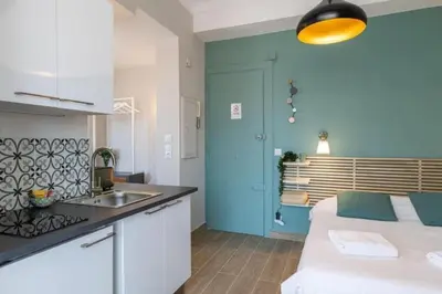 a kitchen with a couch and a sink in a room at MY CASA - LAMARTINE - Studio w terrace and AC Very central in Nice