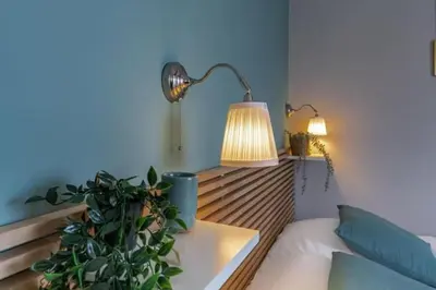 a bedroom with a bed with a lamp and a plant at MY CASA - LAMARTINE - Studio w terrace and AC Very central in Nice