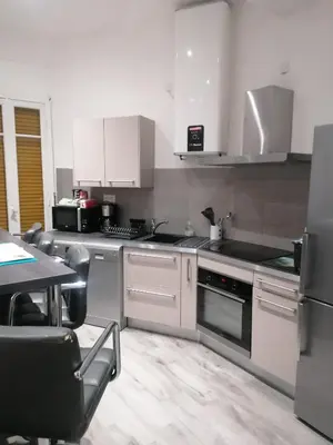 a kitchen with white appliances and a table with chairs at Dolce vita in Nice