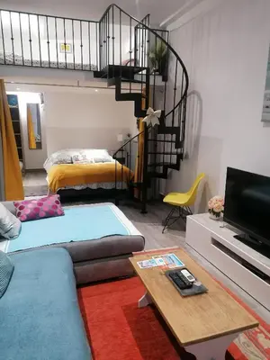 a living room with a couch and a spiral staircase at Dolce vita in Nice