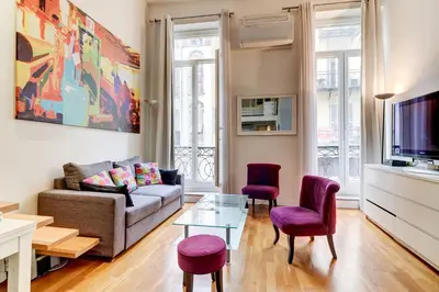 a living room with a couch and chairs and a tv at Spacieux Duplex - Zone Piétonne in Nice