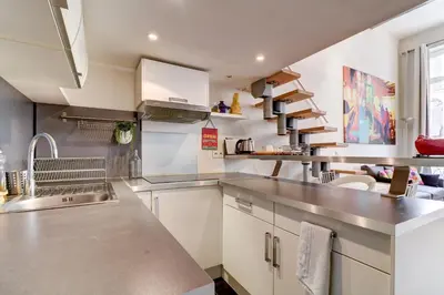 a kitchen with white cabinets and stainless steel counter tops at Spacieux Duplex - Zone Piétonne in Nice