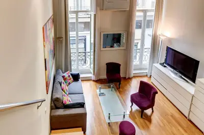 a living room with a couch and a tv at Spacieux Duplex - Zone Piétonne in Nice