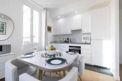 a white kitchen with a white table and chairs at MY CASA - MOULIN - Stunning 1 bedroom Apt on the Port in Nice