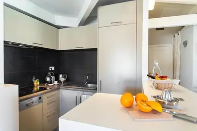 a kitchen with white cabinets and oranges on a counter at MY CASA - ETATS UNIS 896 - Magic view rooftop terrace in Nice