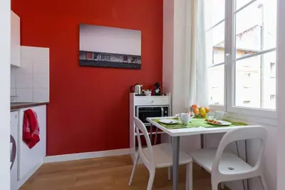 a kitchen with red walls and a table and chairs at MASSENA 33 - Cosy Studio City Center in Nice