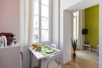 a kitchen with a white table with fruit on it at MASSENA 33 - Cosy Studio City Center in Nice