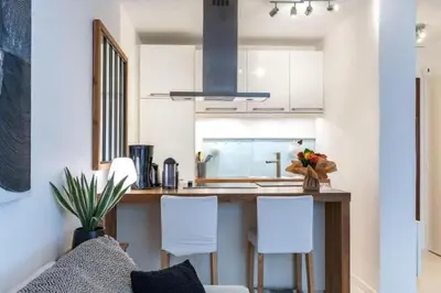 a kitchen with white cabinets and a counter with white chairs at MY CASA - ROSSINI - Central and cosy with AC in Nice