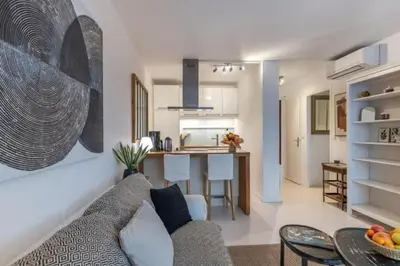 a living room and kitchen with a couch and a table at MY CASA - ROSSINI - Central and cosy with AC in Nice