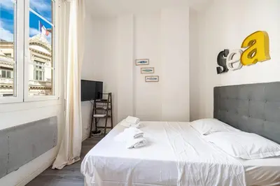 a bedroom with a bed with white sheets and a window at MY CASA - ETATS UNIS 893 - Studio on Seafront in Old Town in Nice