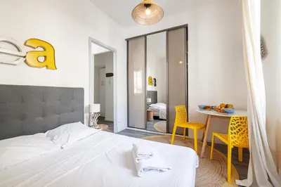 a bedroom with a bed and a table and chairs at MY CASA - ETATS UNIS 893 - Studio on Seafront in Old Town in Nice