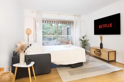 a bedroom with a large white bed and a window at Appartement rénové - Terrasse - Parking - BM in Nice