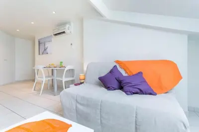 a living room with a gray couch with purple pillows at MY CASA - PORT 2 - Spacious and central w AC on the Port in Nice