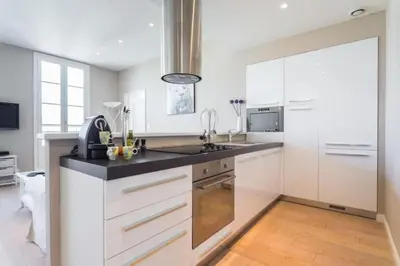 a kitchen with white cabinets and a black counter top at MY CASA - JEAN JAURES - 90m2 w AC 2min to Beach in Nice