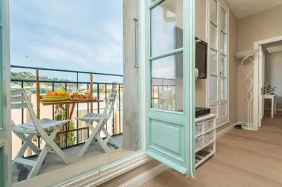 a room with a balcony with a table and chairs at MY CASA - JEAN JAURES - 90m2 w AC 2min to Beach in Nice