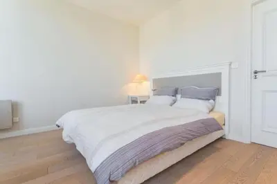 a white bedroom with a large white bed with blue pillows at MY CASA - JEAN JAURES - 90m2 w AC 2min to Beach in Nice