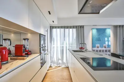 a kitchen with white cabinets and a large window at Sublime Appartement Promenade des Anglais (1) in Nice