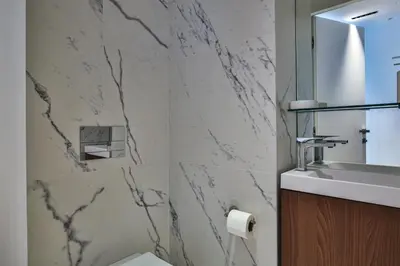 a bathroom with a sink and a marble wall at Sublime Appartement Promenade des Anglais (1) in Nice