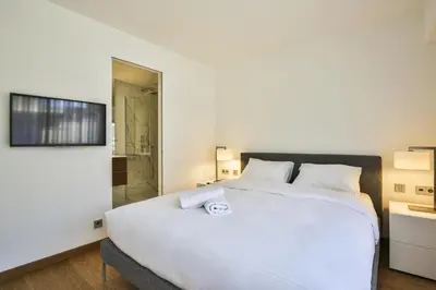 a bedroom with a large white bed and a shower at Sublime Appartement Promenade des Anglais (1) in Nice