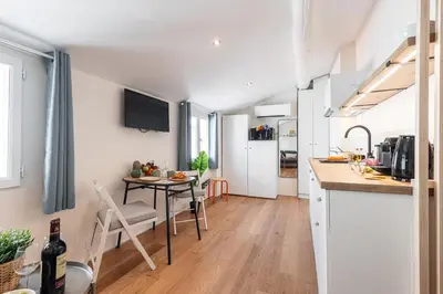 a kitchen and living room with a table and chairs at FEEL HOME - COLLET in Nice