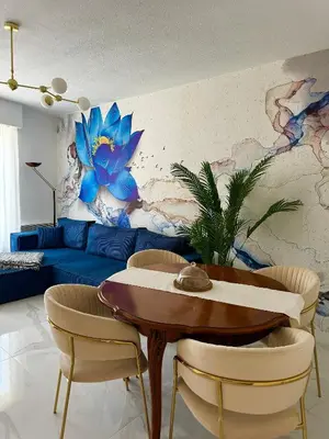 a living room with a blue couch and a table and chairs at L'appartement Azur in Nice