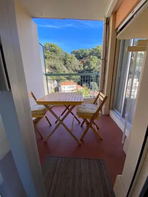 a balcony with a picnic table and two chairs at L'appartement Azur in Nice