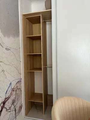 a closet with wooden shelves and a chair at L'appartement Azur in Nice