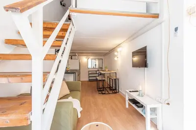 a living room with a staircase in a loft at Lively district - Duplex Old Town in Nice