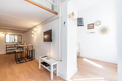 a living room with a table and a kitchen at Lively district - Duplex Old Town in Nice