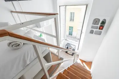 a room with a bed and a staircase with a window at Lively district - Duplex Old Town in Nice