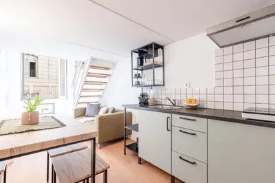 a kitchen with white cabinets and a counter top at Lively district - Duplex Old Town in Nice