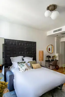 a bedroom with a large bed with a black headboard at 302b Beautiful studio refurbished Downtown / Ac in Nice