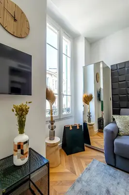 a living room with a blue couch and a mirror at 302b Beautiful studio refurbished Downtown / Ac in Nice