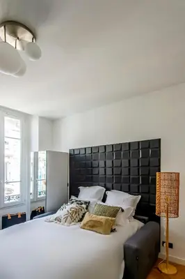 a bedroom with a large white bed with a black headboard at 302b Beautiful studio refurbished Downtown / Ac in Nice