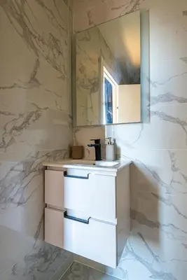 a kitchen with white counters and a marble wall at 304 B Charming apartment refurbished super in Nice