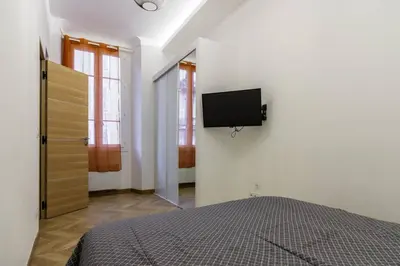 a bedroom with a bed and a tv on the wall at Joli 2 pièces au port de Nice in Nice