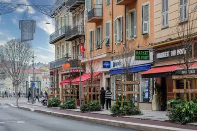 a person standing on a street in front of buildings at Joli 2 pièces au port de Nice in Nice