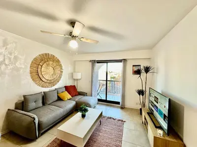 a bedroom with a bed with a ceiling fan and a window at ⁂ Charmant 2 pièces centre-ville avec parking in Cagnes-sur-Mer