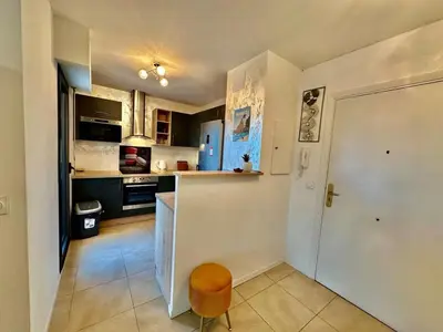 a living room with a table and a couch at ⁂ Charmant 2 pièces centre-ville avec parking in Cagnes-sur-Mer