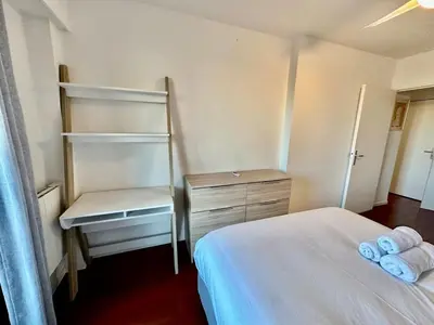 a bedroom with a bed and a shelf and a desk at ⁂ Charmant 2 pièces centre-ville avec parking in Cagnes-sur-Mer