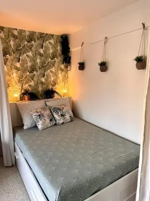 a bed in a room with plants on the wall at Orangers - Bord de mer - Studio cosy 4 personnes in Cagnes-sur-Mer